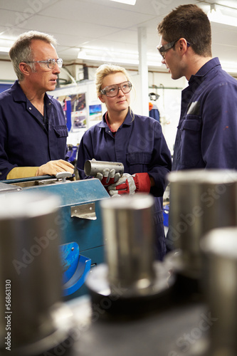 Photo: Engineer Working With Apprentices On Factory Floor Engineer Working With Apprentices On Factory Floor