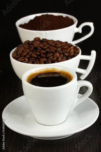 Photo: Different types of coffee in three cups on wooden table Different types of coffee in three cups on wooden table