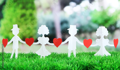 Photo: Paper people in social network concept on green grass outdoors Paper people in social network concept on green grass outdoors