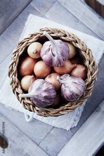 Photo: Onions and garlic bulbs in a rustic basket Onions and garlic bulbs in a rustic basket