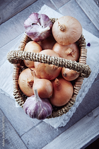 Photo: Onions and garlic bulbs in a rustic basket Onions and garlic bulbs in a rustic basket
