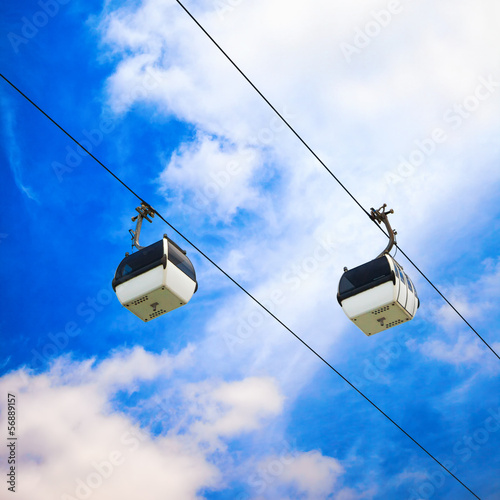 Photo: Two cable car on a partly cloudy sky background Two cable car on a partly cloudy sky background