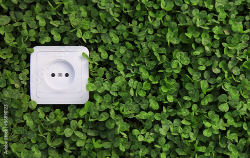 Photo: electric power receptacle on a green grass background electric power receptacle on a green grass background