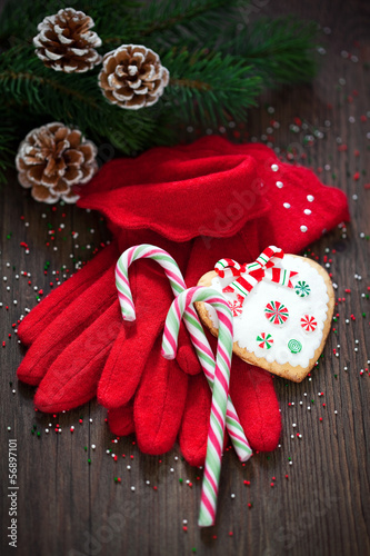 Photo: Red knitted gloves, Christmas candy canes and cookies Red knitted gloves, Christmas candy canes and cookies