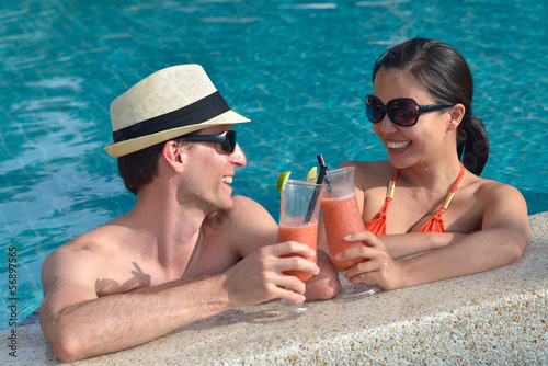 Photo: happy young couple relax and take fresh drink on poolside happy young couple relax and take fresh drink on poolside