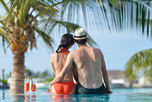 Photo: happy young couple relax and take fresh drink on poolside happy young couple relax and take fresh drink on poolside
