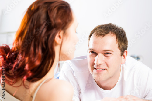 Photo: young man lying in bed with his girlfriend young man lying in bed with his girlfriend