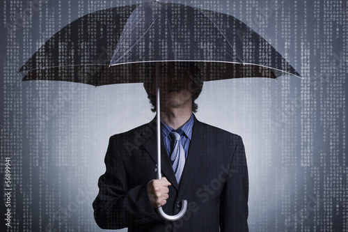 Photo: Businessman with an umbrella under digital rain. Businessman with an umbrella under digital rain.