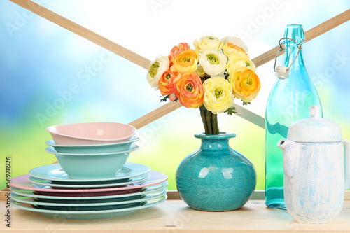 Photo: Beautiful dishes on wooden cabinet on natural background Beautiful dishes on wooden cabinet on natural background