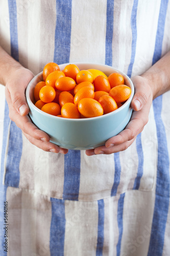 Photo: man hands holding bowl of kumquat man hands holding bowl of kumquat