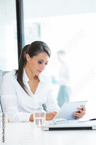 Photo: Businesswoman working on her digital tablet Businesswoman working on her digital tablet