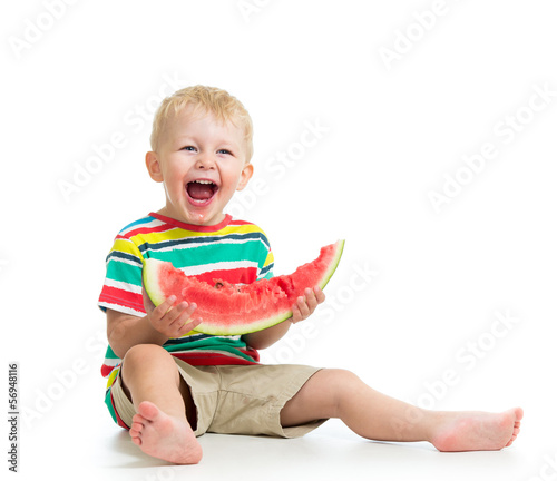 Photo: Kid boy eating watermelon isolated on white Kid boy eating watermelon isolated on white