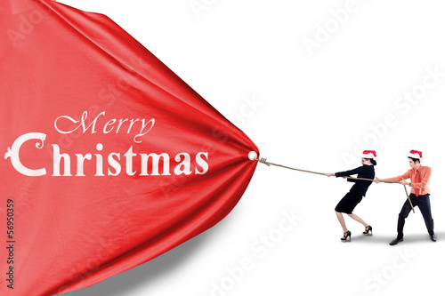 Photo: Business team pull christmas banner Business team pull christmas banner