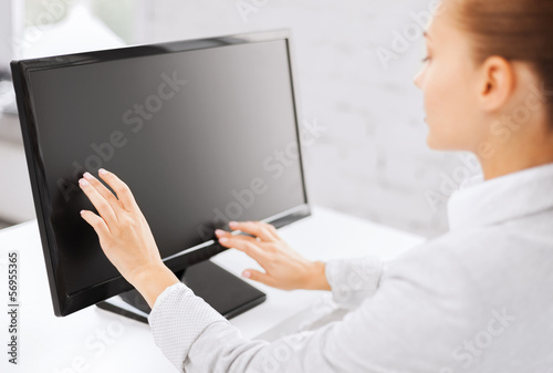 Photo: smiling businesswoman with touchscreen in office smiling businesswoman with touchscreen in office
