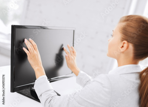 Photo: smiling businesswoman with touchscreen in office smiling businesswoman with touchscreen in office