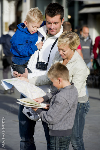 Photo: Young family looking at map in the city Young family looking at map in the city
