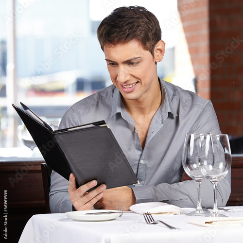 Photo: Mann liest Getränkekarte im Restaurant Mann liest Getränkekarte im Restaurant
