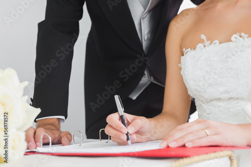 Photo: Close up of young bride signing wedding contract Close up of young bride signing wedding contract