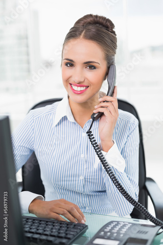 Photo: Smiling brunette businesswoman phoning Smiling brunette businesswoman phoning