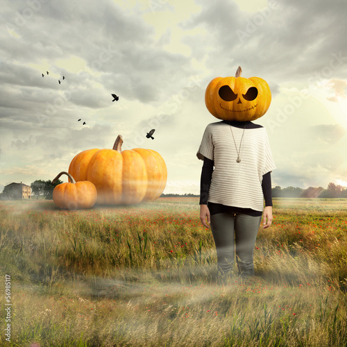 Photo: Young girl with pumpkin head, halloween Young girl with pumpkin head, halloween