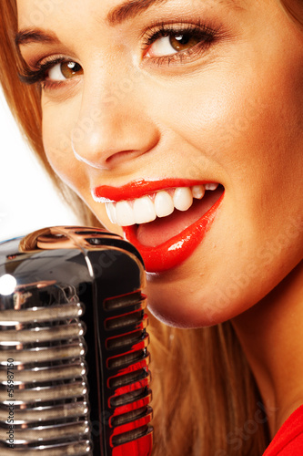 Photo: Beautiful woman singing into a microphone Beautiful woman singing into a microphone