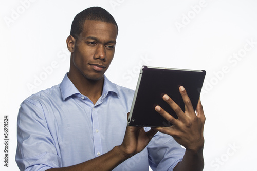 Photo: Black man typing on his electronic tablet, horizontal Black man typing on his electronic tablet, horizontal