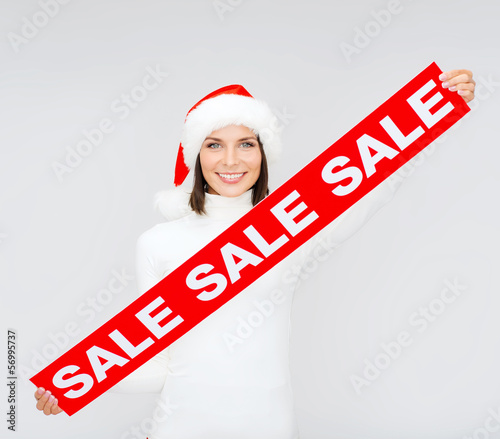 Photo: woman in santa helper hat with red sale sign woman in santa helper hat with red sale sign