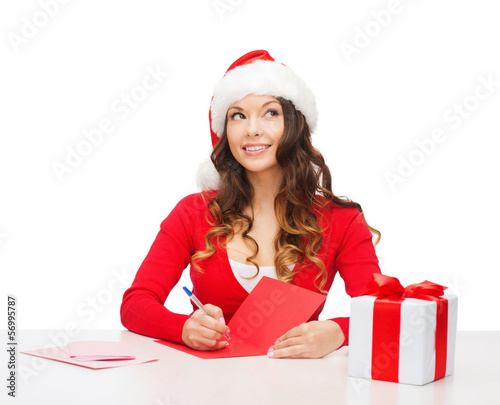 Photo: smiling woman in santa helper hat with postcard smiling woman in santa helper hat with postcard