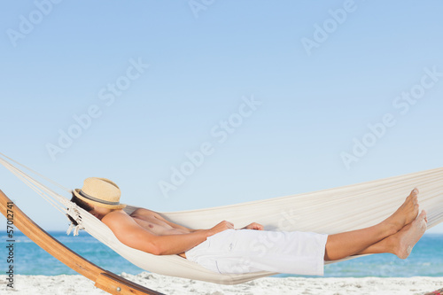 Photo: Man wearing straw hat relaxing in a hammock Man wearing straw hat relaxing in a hammock
