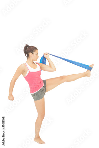 Photo: Calm sporty brunette exercising with resistance band Calm sporty brunette exercising with resistance band