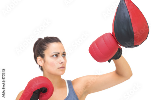 Photo: Serious sporty brunette training with punching bag Serious sporty brunette training with punching bag