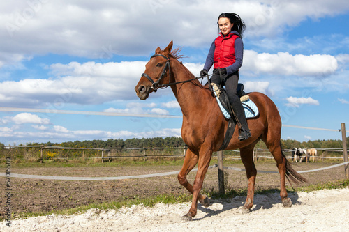 Photo: Young woman riding a horse Young woman riding a horse