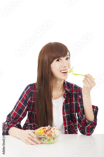 Photo: smiling young woman eating fruits and salad smiling young woman eating fruits and salad