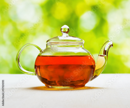Photo: Teapot of fresh tea on natural background Teapot of fresh tea on natural background