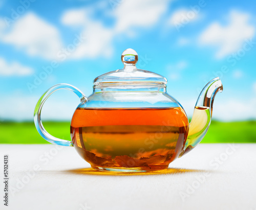 Photo: Teapot of fresh tea on natural background Teapot of fresh tea on natural background