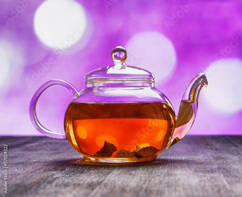 Photo: Teapot of fresh tea on purple background Teapot of fresh tea on purple background