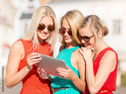 Photo: beautiful girls toursits looking into tablet pc beautiful girls toursits looking into tablet pc