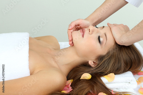 Photo: Beautiful young woman during facial massage in cosmetic salon Beautiful young woman during facial massage in cosmetic salon