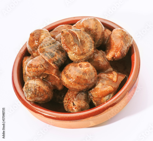 Photo: escargot cooked in sauce served in earthenware dish escargot cooked in sauce served in earthenware dish