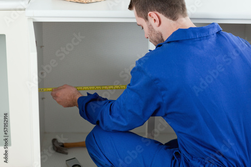 Photo: Focused repair man measuring something Focused repair man measuring something