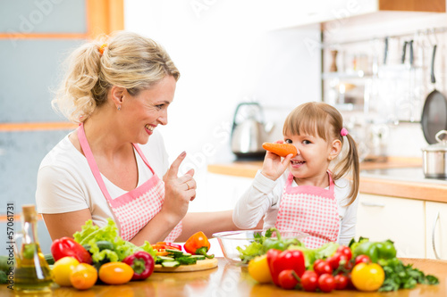 Photo: mother and her child preparing healthy food and having fun mother and her child preparing healthy food and having fun