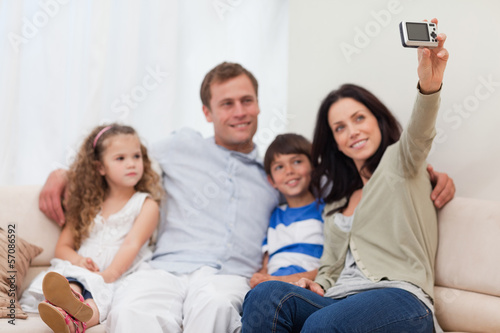 Photo: Mother taking a family picture on the couch Mother taking a family picture on the couch