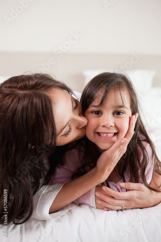 Photo: Portrait of a mother kissing her daughter Portrait of a mother kissing her daughter