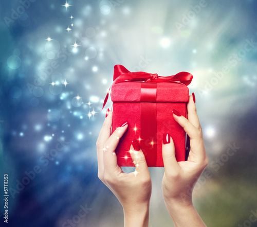 Photo: Red present box held up by in a woman's hands Red present box held up by in a woman's hands