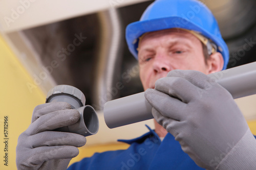 Photo: Plumber holding two parts of plastic pipe Plumber holding two parts of plastic pipe