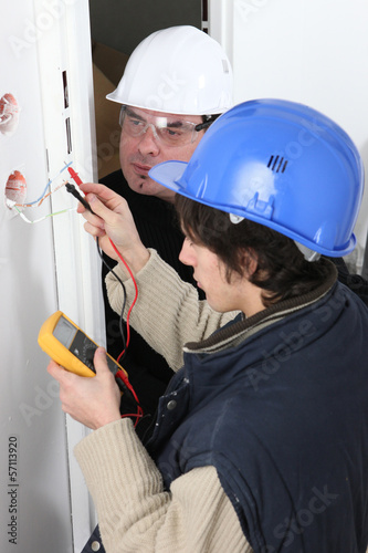 Photo: Worker using a multimeter Worker using a multimeter