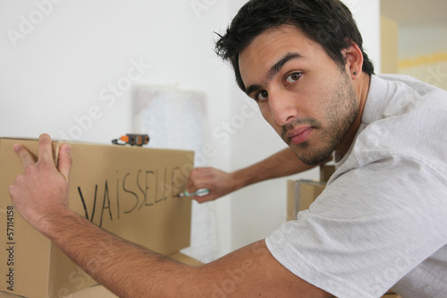 Photo: Man packing boxes for the big move Man packing boxes for the big move