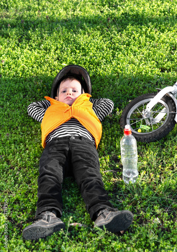 Photo: Small boy taking a rest on the grass Small boy taking a rest on the grass
