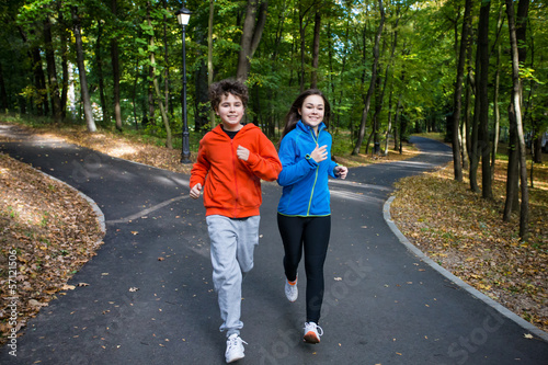 Photo: Girl and boy running, jumping in park Girl and boy running, jumping in park