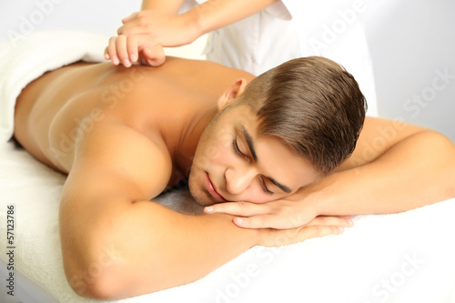 Photo: Young man having back massage close up Young man having back massage close up